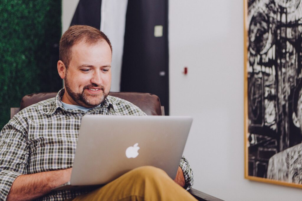 a bearded white man using a laptop