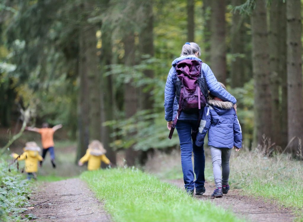 woman and child walking in a forest