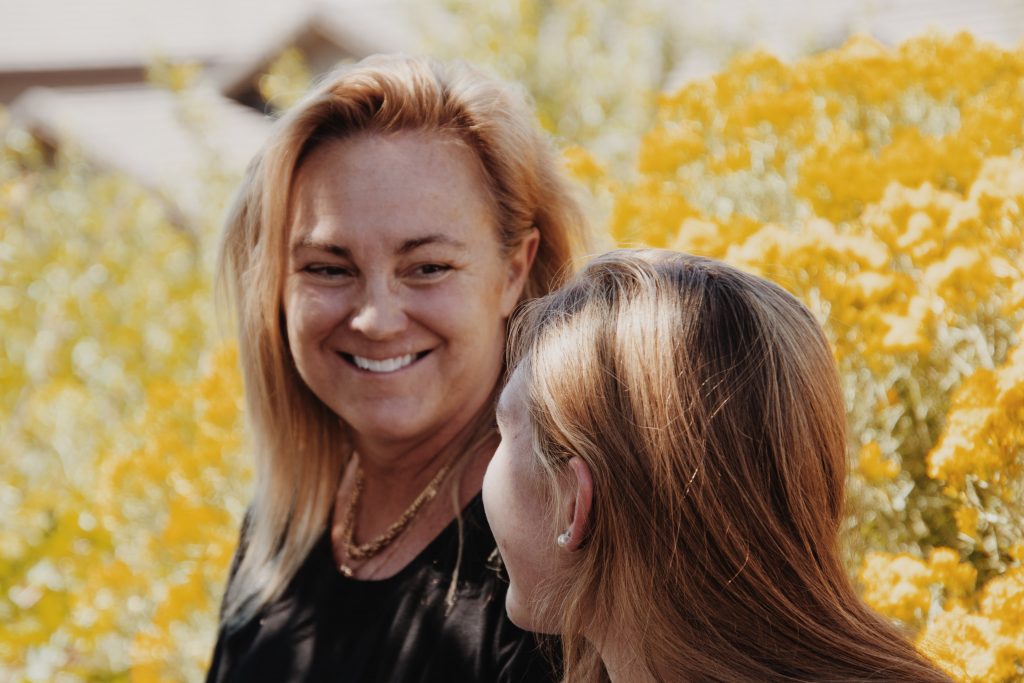 an older blonde woman smiling at a younger blonde woman