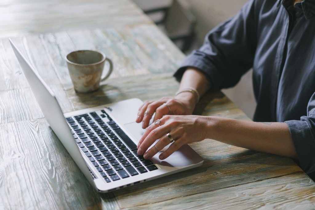 Woman's hands typing on a laptop