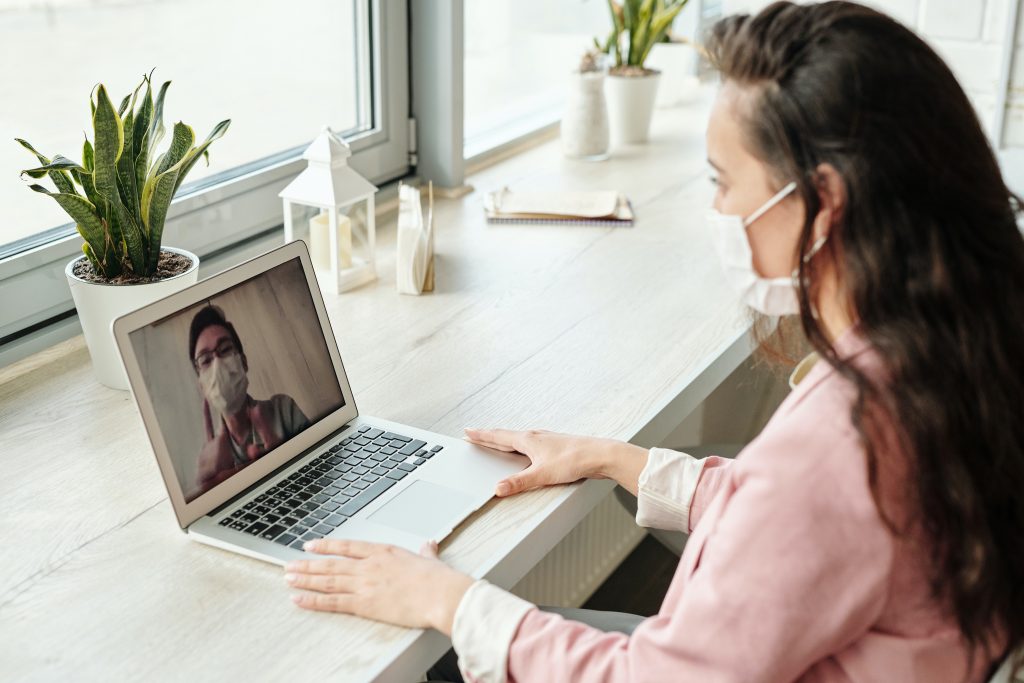 Woman wearing face mask facetiming man wearing face mask