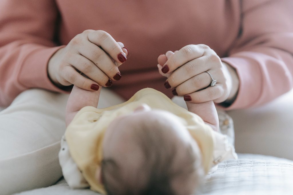 Woman holding babies hands