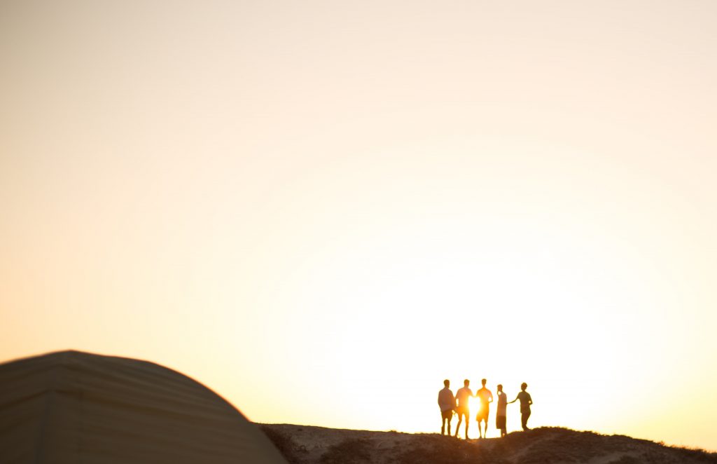 Group of people walking in the sun set