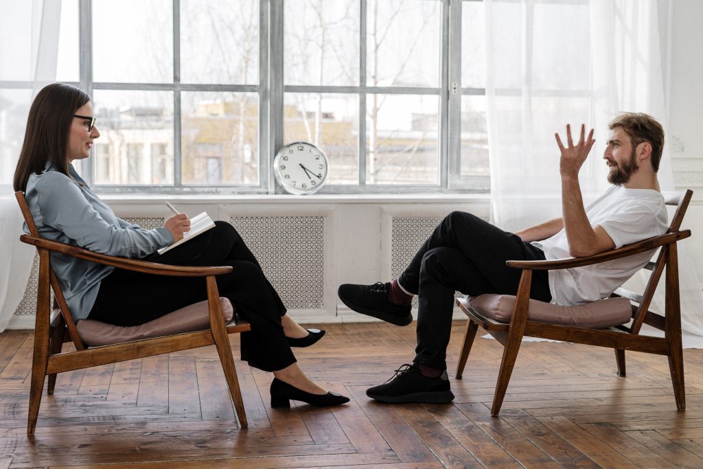 Man talking while woman takes notes